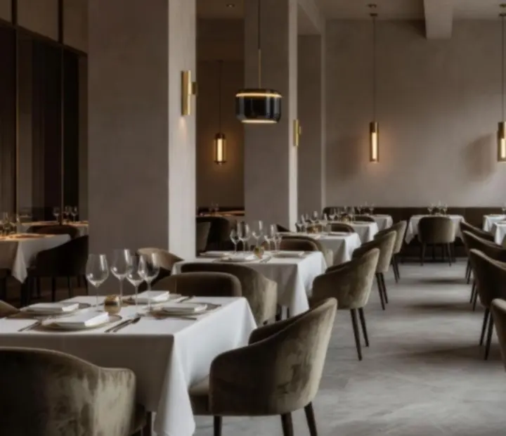 Eleganckie, designerskie wnętrze restauracji Polvera Stino z nakrytymi stołami i nastrojowym oświetleniem.